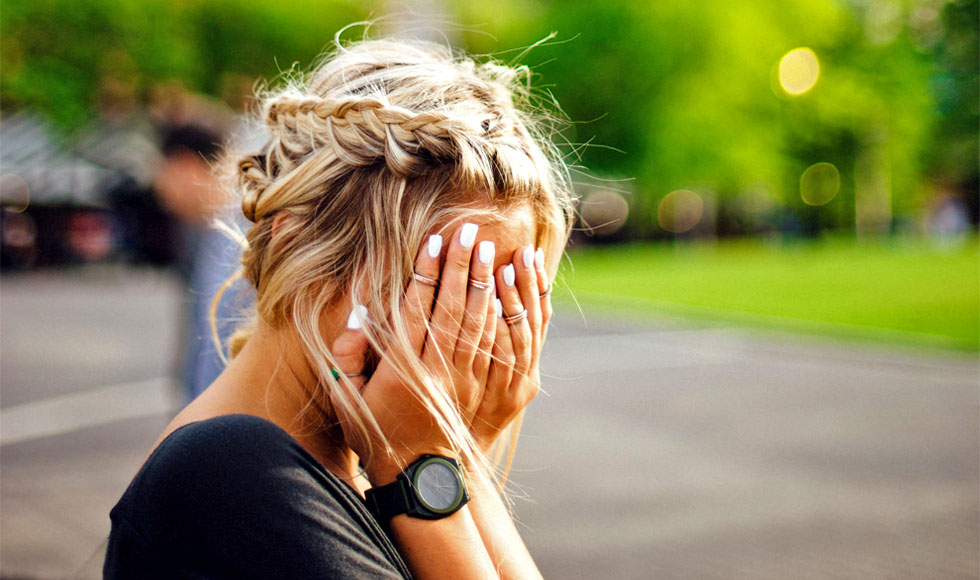 woman covering face with hands