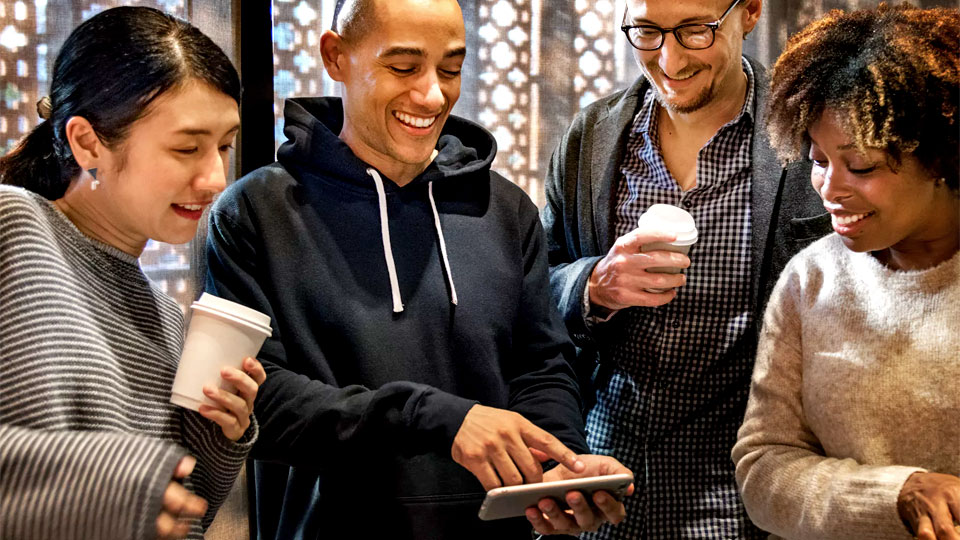 people at the office laughing with the smartphone