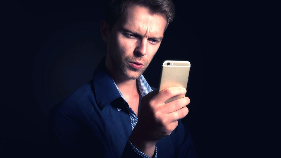 surprised man looking at his iphone