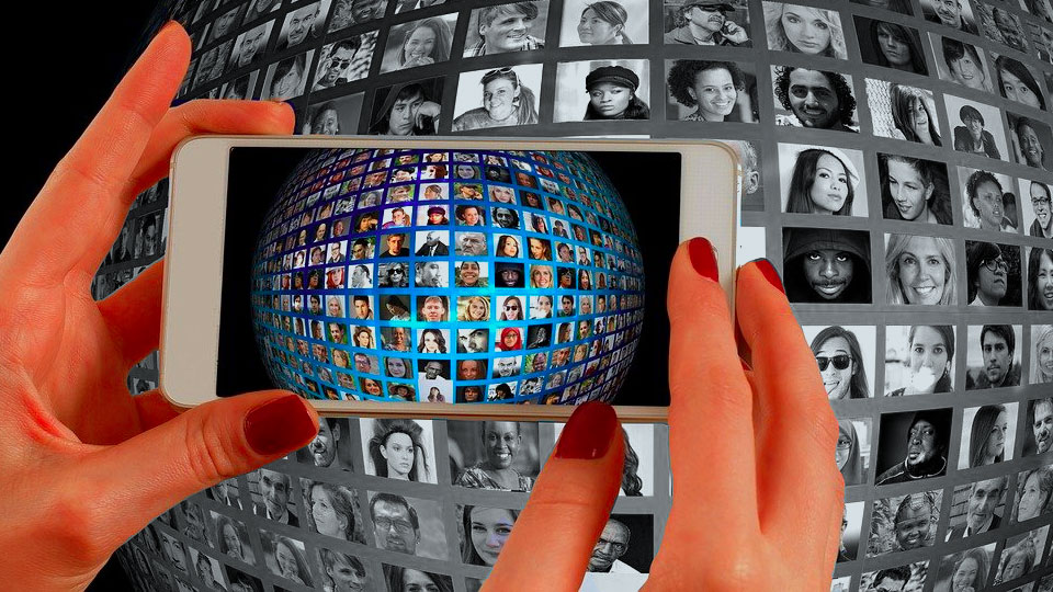 woman hands holding smartphone with many faces and contacts