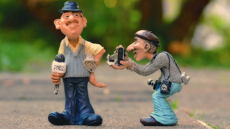 journalist doll with a microphone and another doll with a camera