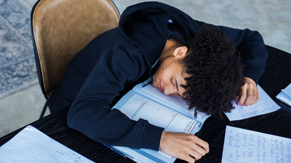 student sleeping on the books