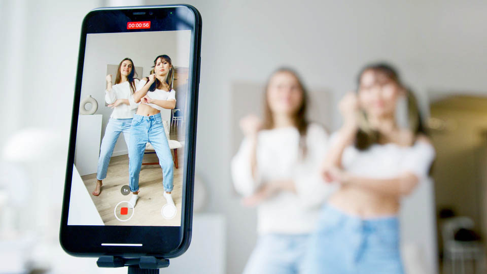 two women recording a video by smartphone 