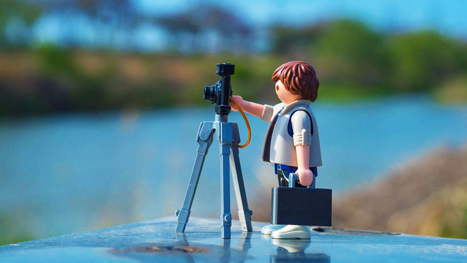 a playmobil doll with a camera and tripod
