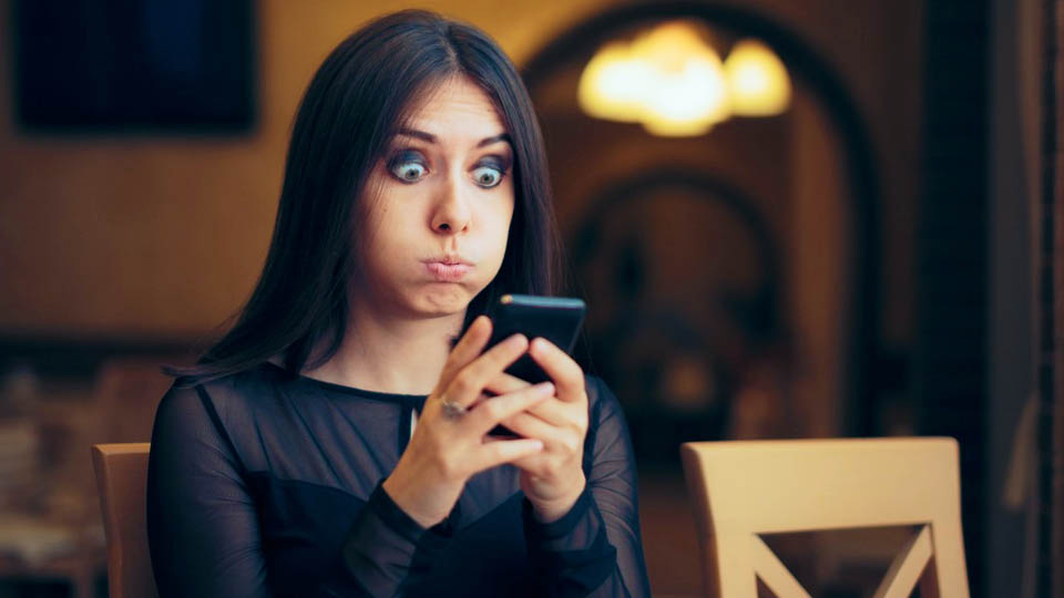frightened woman looking at her smartphone