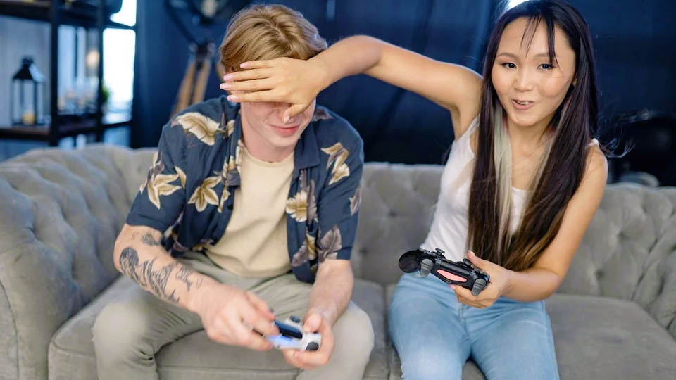 a couple playing video games on the sofa