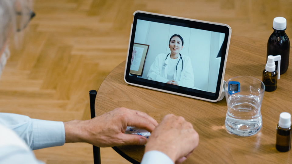 a tablet on a table with a doctor doing remote care