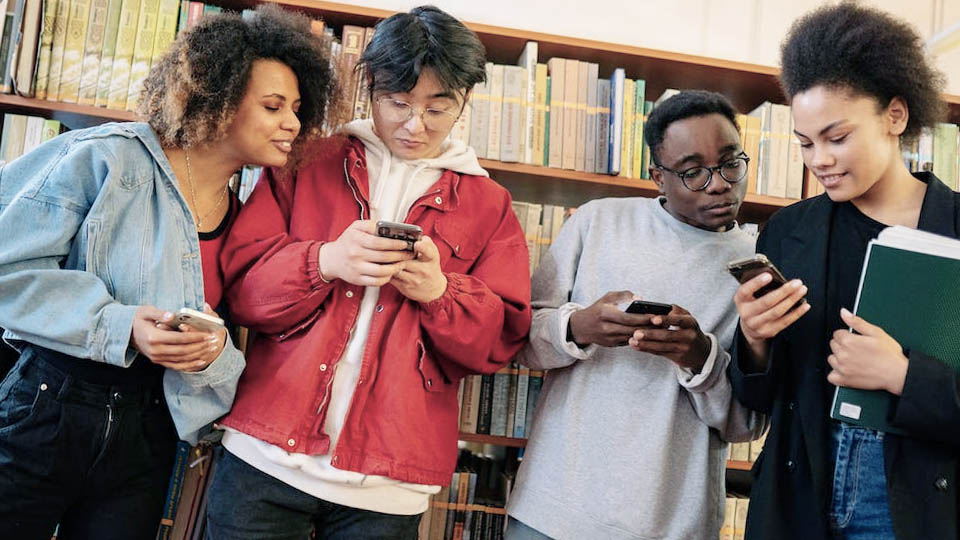 students with their smartphone in the library