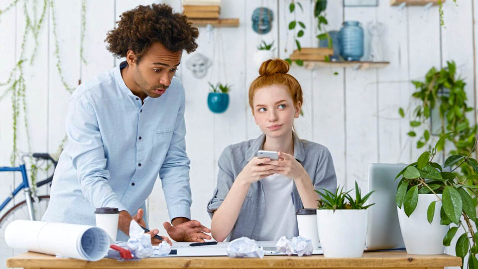 a worried man and woman working with laptop and smartphone