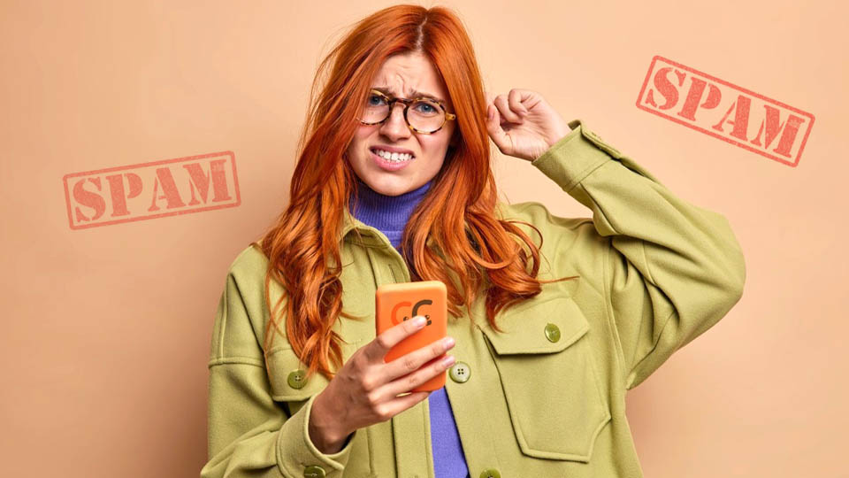 redheaded woman disappointed by spam on her phone