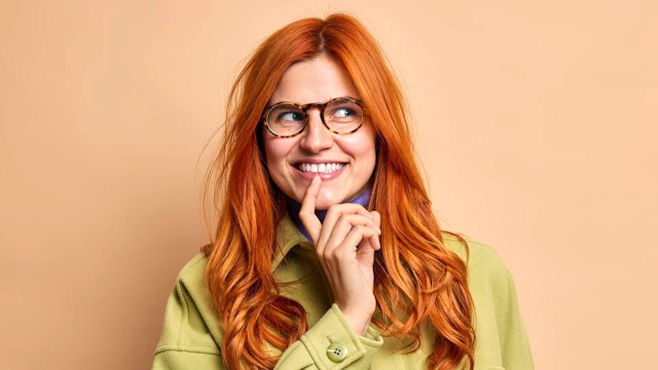 red-haired woman thinking and smiling