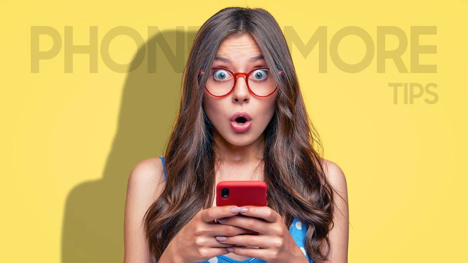 a woman in glasses surprised with the smartphone in her hands