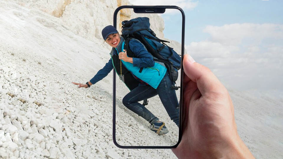uno smartphone che scatta una foto di una donna che scala la montagna