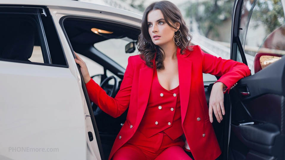 a well-dressed woman sitting in a luxury car