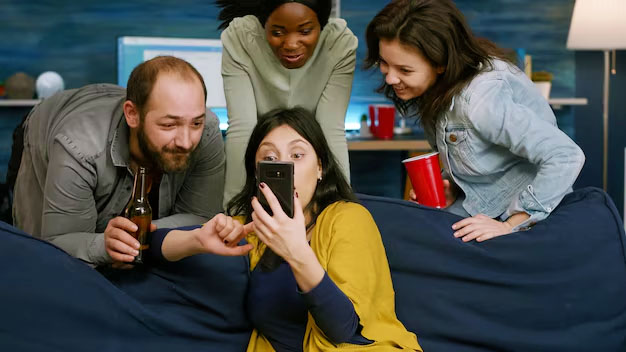 quattro persone che si divertono sul divano guardando il cellulare