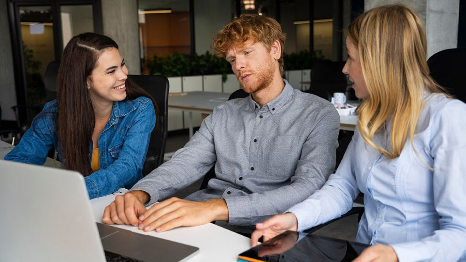 un uomo preoccupato in ufficio tra due donne eccitate