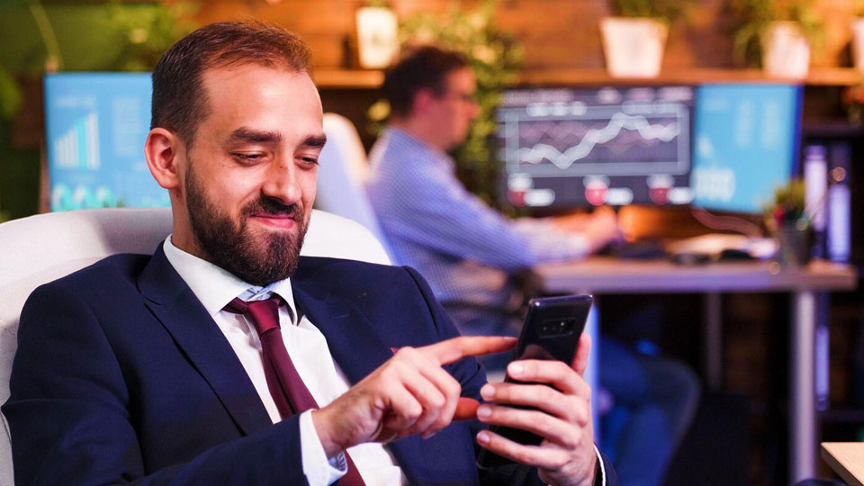 businessman in the office with his smartphone in hand