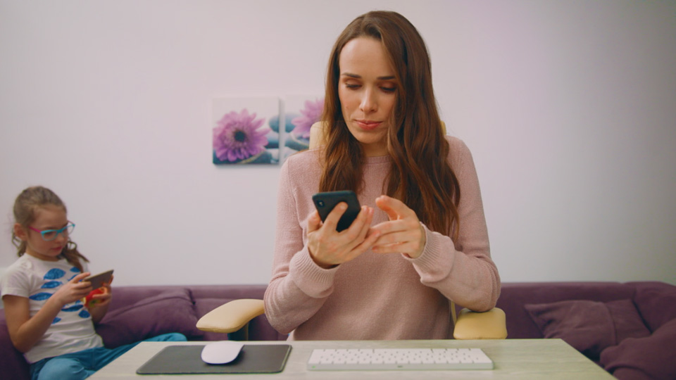 mulher trabalhando em casa com o celular