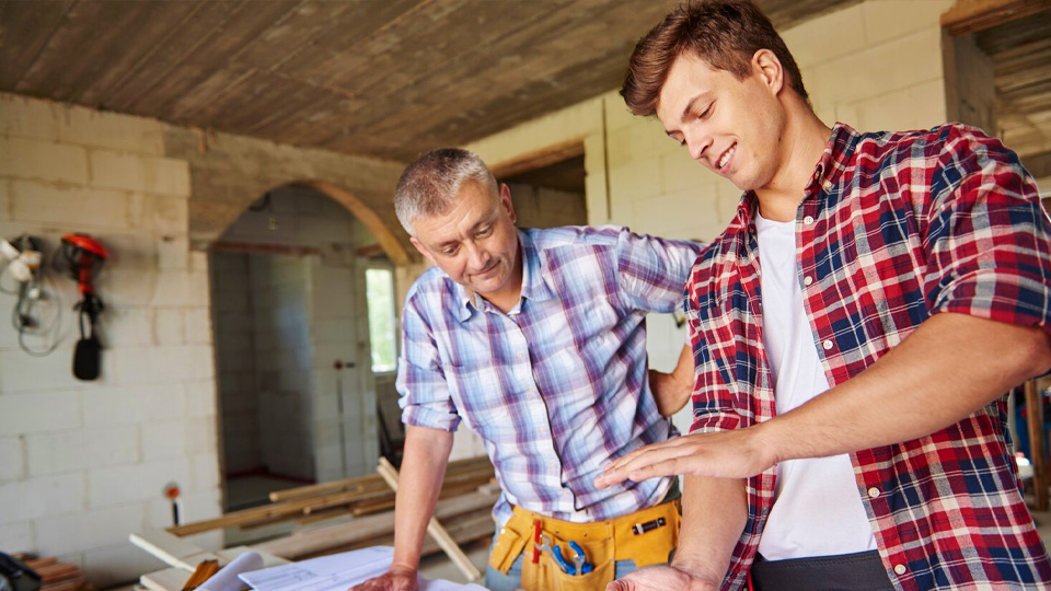 un charpentier expérimenté et un jeune propriétaire d'entreprise de rénovation domiciliaire