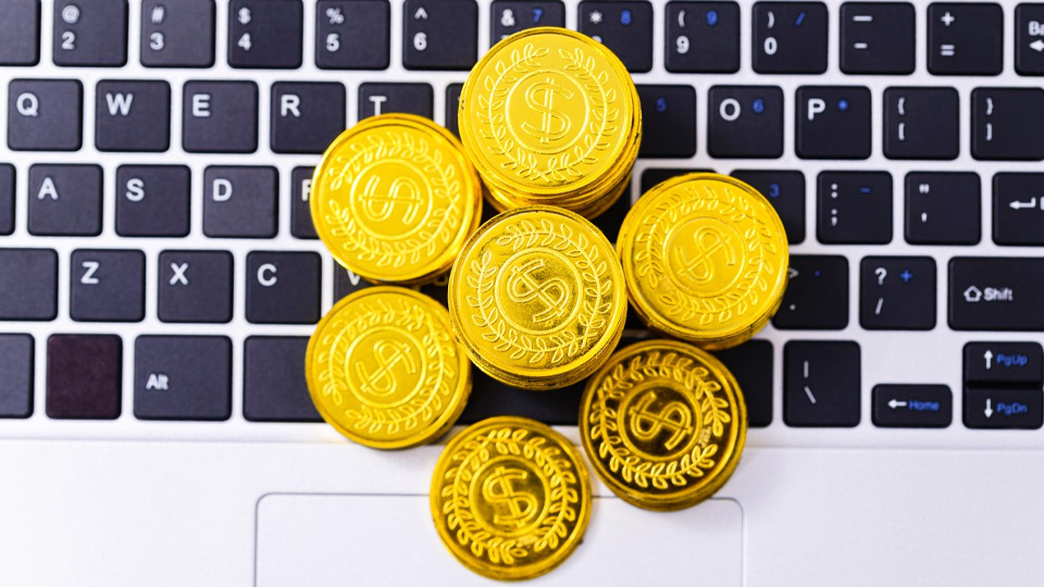 des pièces d'or sur un ordinateur portable représentant des cryptomonnaies