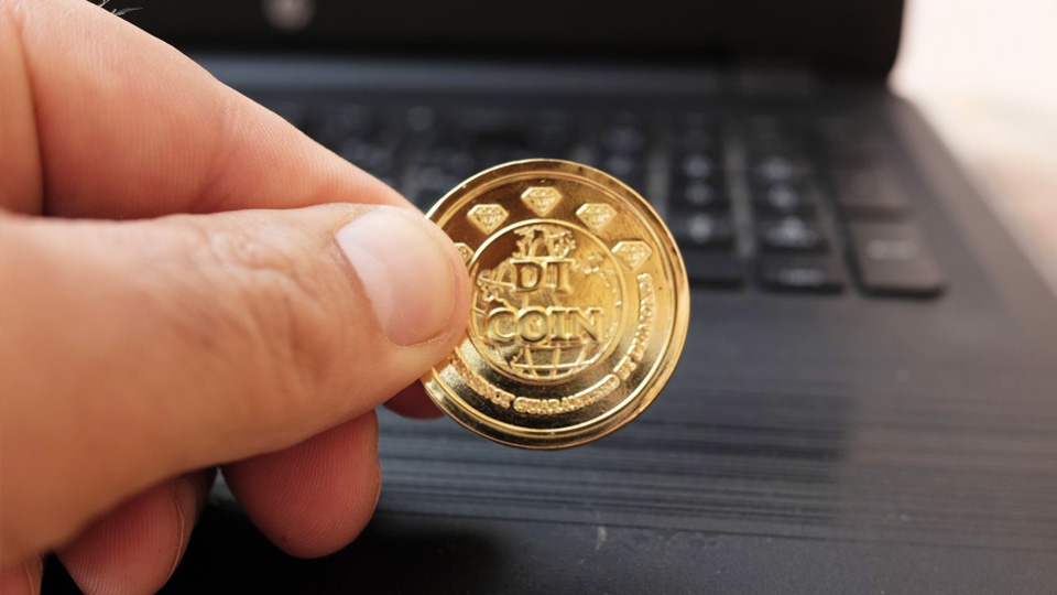 tenant une pièce de monnaie étiquetée DT Coin